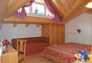 a bedroom with a bed and a window at Hotel La Roccia in Passo del Tonale