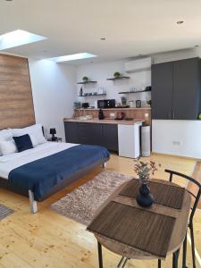 a bedroom with a bed and a table and a kitchen at Várfal apartman II in Eger