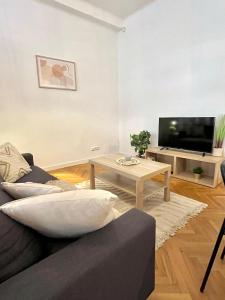 Apartment Mia - Old Town في براتيسلافا: غرفة معيشة مع أريكة وطاولة