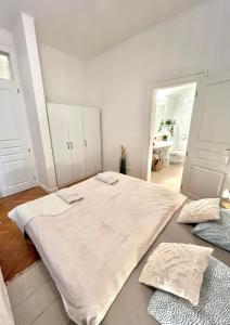 Apartment Mia - Old Town في براتيسلافا: غرفة نوم بيضاء فيها سرير كبير