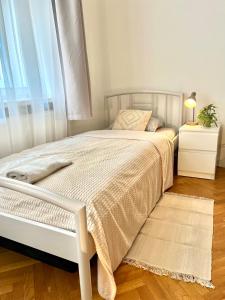 een slaapkamer met een wit bed en een raam bij Apartment Mia - Old Town in Bratislava