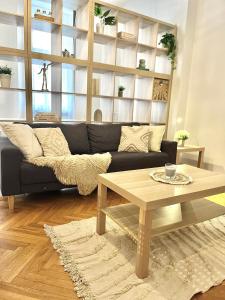 Apartment Mia - Old Town في براتيسلافا: غرفة معيشة مع أريكة سوداء وطاولة قهوة