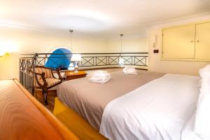a hotel room with two beds and a chair at Flat Rosanna in Sorrento