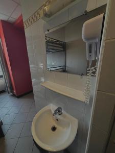 a bathroom with a sink and a phone on the wall at Peace & Love Hostel in Paris