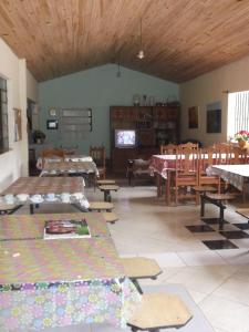 ein Wohnzimmer mit Tischen und Stühlen und ein Zimmer mit Tischen in der Unterkunft Sítio Colina das Flores. Lugar Encantador com Piscina para Grupos in Franco da Rocha