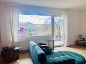 a living room with a blue couch and a large window at Mosel Quartier 32 in Brodenbach