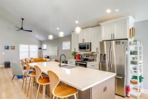 a kitchen with white cabinets and a kitchen island with chairs at Chic Spacious AVL Oasis with Hot Tub and Fire Pit in Asheville