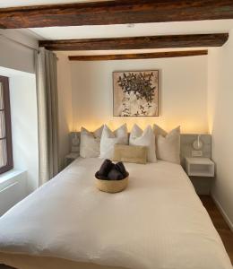 a bedroom with a white bed with a basket on it at Gîte Du XVe in Kaysersberg
