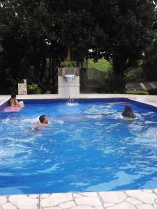 zwei Personen schwimmen in einem Pool mit Springbrunnen in der Unterkunft Sítio Colina das Flores. Lugar Encantador com Piscina para Grupos in Franco da Rocha