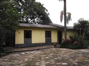 ein Haus mit einer Palme davor in der Unterkunft Sítio Colina das Flores. Lugar Encantador com Piscina para Grupos in Franco da Rocha