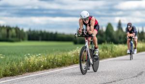 two people riding bikes down a road at EnjoyNature B&B in Lahti