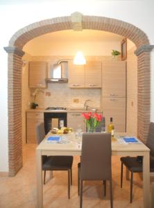 een keuken met een tafel en stoelen en een boog bij Il sogno di Rosa in Massa Lubrense