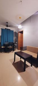 uma sala de estar com vários bancos e uma mesa em Tulip Homes by The Oaks Inn em Cochin