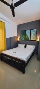 een groot bed in een kamer met 2 ramen bij Tulip Homes by The Oaks Inn in Cochin