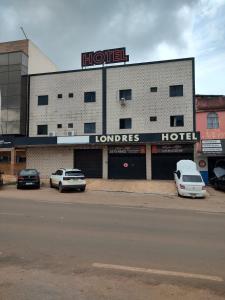 a hotel with cars parked in a parking lot at LONDRES HOTEL in Gama