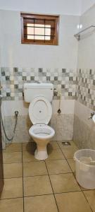 La salle de bains est pourvue d'une douche et de toilettes. dans l'établissement Tulip Homes by The Oaks Inn, à Cochin