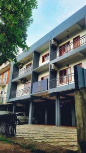 a building with balconies and a car parked in front of it at Tulip Homes by The Oaks Inn in Cochin