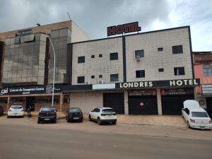 a hotel with cars parked in a parking lot at LONDRES HOTEL in Gama