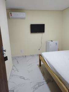 a room with a bed and a television on a wall at LONDRES HOTEL in Gama
