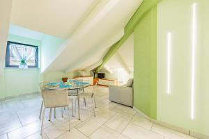 a dining room with green walls and a table and chairs at Green House in Marina dʼAndora