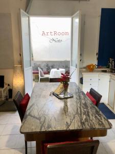 una cocina con una mesa con un jarrón de flores. en ArtRoom Garden, en Noto