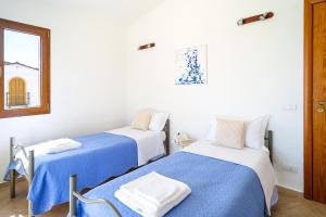 トルトリにあるAttico Luxuryのベッド2台(青と白のシーツ付)が備わる客室です。