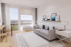 a living room with a couch and a large window at Dexter Suite in Elk Rapids