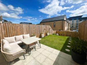 a patio with a table and chairs and a fence at Seagrass in Sandown