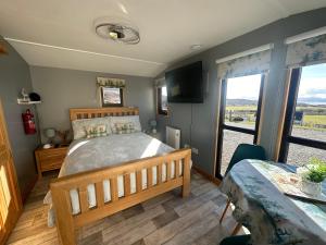 a bedroom with a bed and a large window at Duirinish Pods with Private Hot Tubs and Duirinish Bothy with No Hot Tub in Plockton