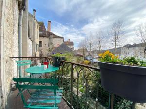 a balcony with a table and chairs on a railing at Gorgeous old house in the centre of Souillac in Souillac