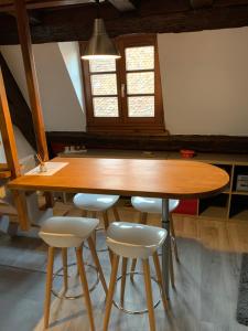 einen Holztisch mit Hockern in einem Zimmer in der Unterkunft Appartement Duplex 2a Rue d'Alspach in Colmar + 7 Fotos