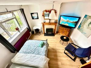 倫敦的住宿－Whitechapel Rooms R1，一间卧室配有一张床和一台电视