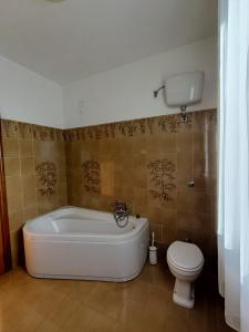 La salle de bains est pourvue d'une baignoire blanche et de toilettes. dans l'établissement La Finestra Sui Monti, à Arcevia