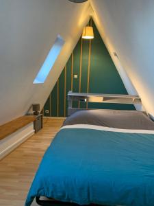 ein Schlafzimmer mit einem blauen Bett und einer grünen Wand in der Unterkunft Appartement Duplex 2a Rue d'Alspach in Colmar
