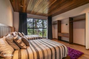 una camera da letto con un letto grande e una grande finestra di Cabaña de lujo en La Toscana Mazamitla 1 a Mazamitla