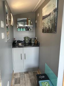 a small kitchen with two pots and pans on a counter at Duirinish Pods with Private Hot Tubs and Duirinish Bothy with No Hot Tub in Plockton