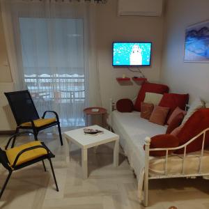 a bedroom with a bed and a tv on the wall at Family Apartment in Patra