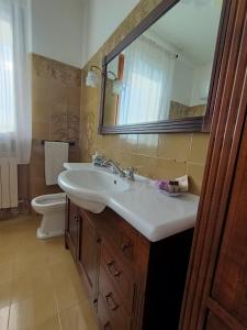 a bathroom with a sink and a toilet and a mirror at La Finestra Sui Monti in Arcevia