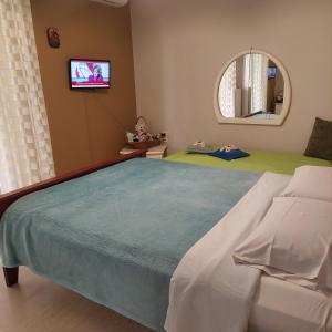 ein Schlafzimmer mit einem großen Bett und einem TV in der Unterkunft Family Apartment in Patras