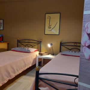 a bedroom with two beds and a table with a lamp at Family Apartment in Patra