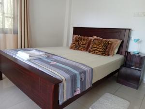 1 cama con cabecero de madera y almohadas en Lake Life Villa, en Ambalangoda