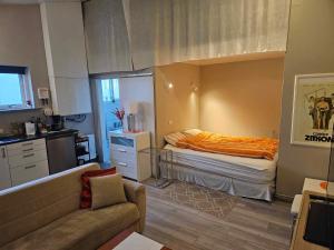 a bedroom with a bed with an orange blanket at Private studio apartment near the airport in Ytri-Njarðvík