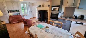 een keuken met een tafel en stoelen in een kamer bij Gîtes à la campagne - La Petite Clavelie in Ribérac