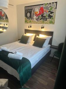 a hotel room with a large bed with white sheets at Hotell City Karlshamn in Karlshamn