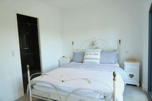 ein weißes Schlafzimmer mit einem weißen Bett und gestreiften Kissen in der Unterkunft Grimaud Jardin Boreals 3 Bed Luxury Appt in Grimaud + 17 Fotos