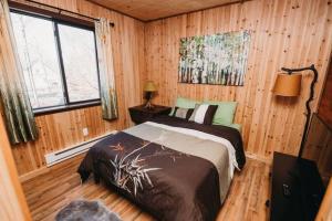 een slaapkamer met een bed in een kamer met houten wanden bij Cozy Cabin in Pocono Farms with Hot tub Fire pit and close to many attractions in Pocono Country Place