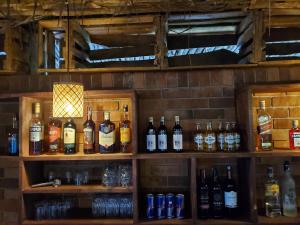 a shelf filled with lots of bottles of alcohol at Kizumba House in Arusha +67 photos