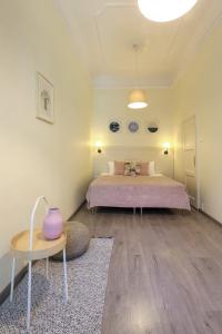 Un dormitorio con una cama y una mesa con un jarrón. en Ozone Private Rooms, en Budapest