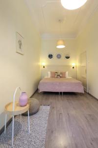 ブダペストにあるOzone Private Roomsのベッドルーム1室(ベッド1台、花瓶付きのテーブル付)