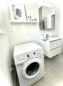 a washing machine in a bathroom with a sink at Magnifique appartement - Quartier Louise! in Brussels